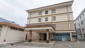 Un edificio a più piani con un ingresso coperto, ampie finestre e un balcone.