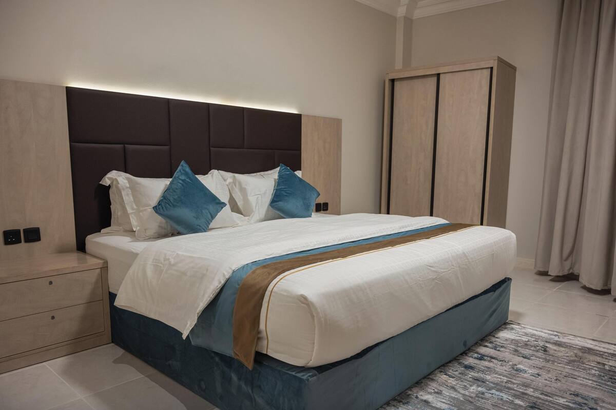 Une chambre à coucher moderne avec un lit, des tables de chevet et une armoire.