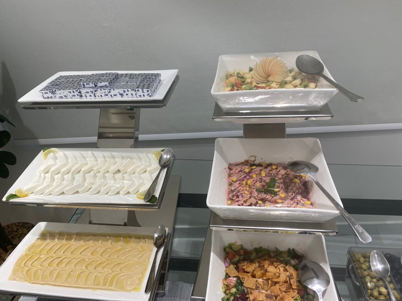 A buffet with various dishes, including a white dessert, a salad, and a dish with corn and meat.