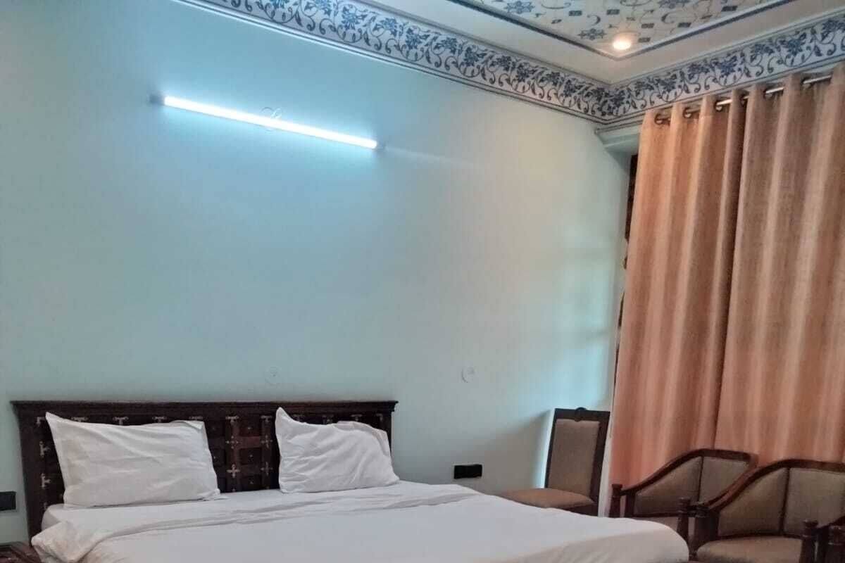 A bedroom with a wooden bed, a nightstand, a chair, and a ceiling light.