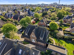 A residential area with houses, trees, and a clear sky. - Stadum Hüs - Charming vacation home for four people with its own garden in (Westerland)
