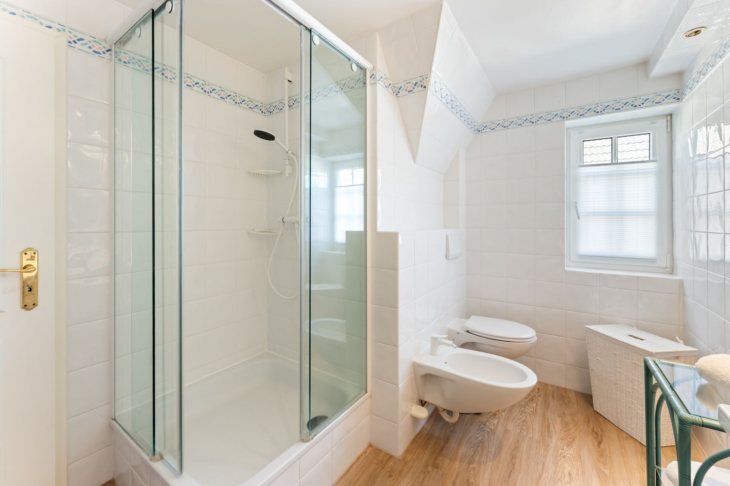 Ein Badezimmer mit Duschkabine, Toilette und Waschbecken.