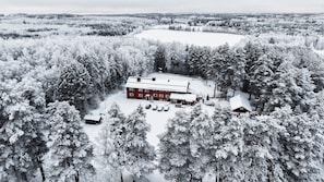 Un edificio rojo rodeado de árboles cubiertos de nieve, con vistas despejadas del bosque circundante.