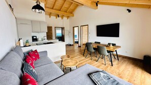 Un espacio habitable moderno con sofá, mesa de comedor y área de cocina.