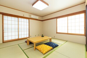 Ein traditioneller japanischer Raum mit Tatami-Böden, einem niedrigen Holztisch und Shoji-Schirmwänden.