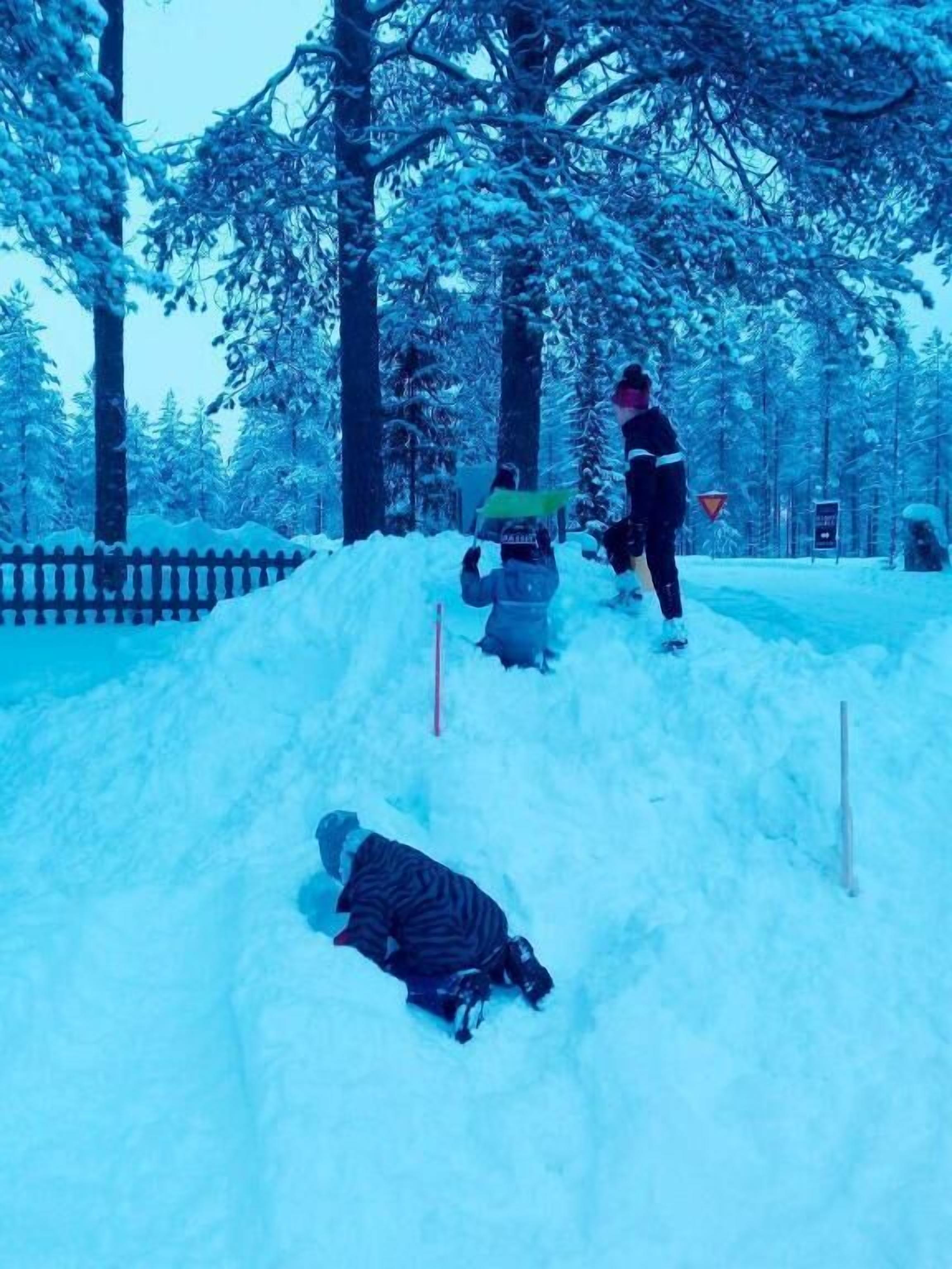 Escena nevada al aire libre con una persona de pie y otra acostada en la nieve.
