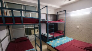 A dormitory room with bunk beds, a window, and a radiator. - Vrindavan Bunk Hostel by Shiva - 5min Walk from Prem Mandir (Vrindavan)