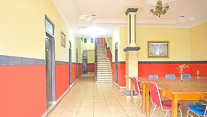 A hallway with a staircase, a dining area with a table and chairs, and a framed picture on the wall. - Cozy Twin Escape in Indonesia with Free WiFi (Bandar Lampung)