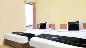 Two beds with white bedding and black accents, a window with a curtain, and a beige wall. - Cozy Twin Escape in Indonesia with Free WiFi (Bandar Lampung)