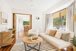 A modern living room with a sofa, coffee table, and dining area. - Escape Away by Ready Set Stay (Cowes)