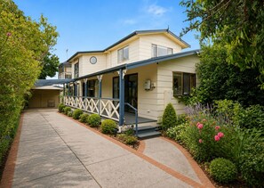 A two-story building with a covered porch and a driveway. - Escape Away by Ready Set Stay (Cowes)