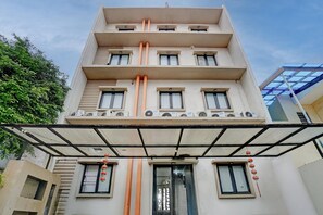 Ein mehrstöckiges Gebäude mit schlichter Fassade, zahlreichen Fenstern und Klimaanlagen.