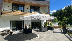 En modern byggnad med en uteplats, utomhusmöbler och planteringar.