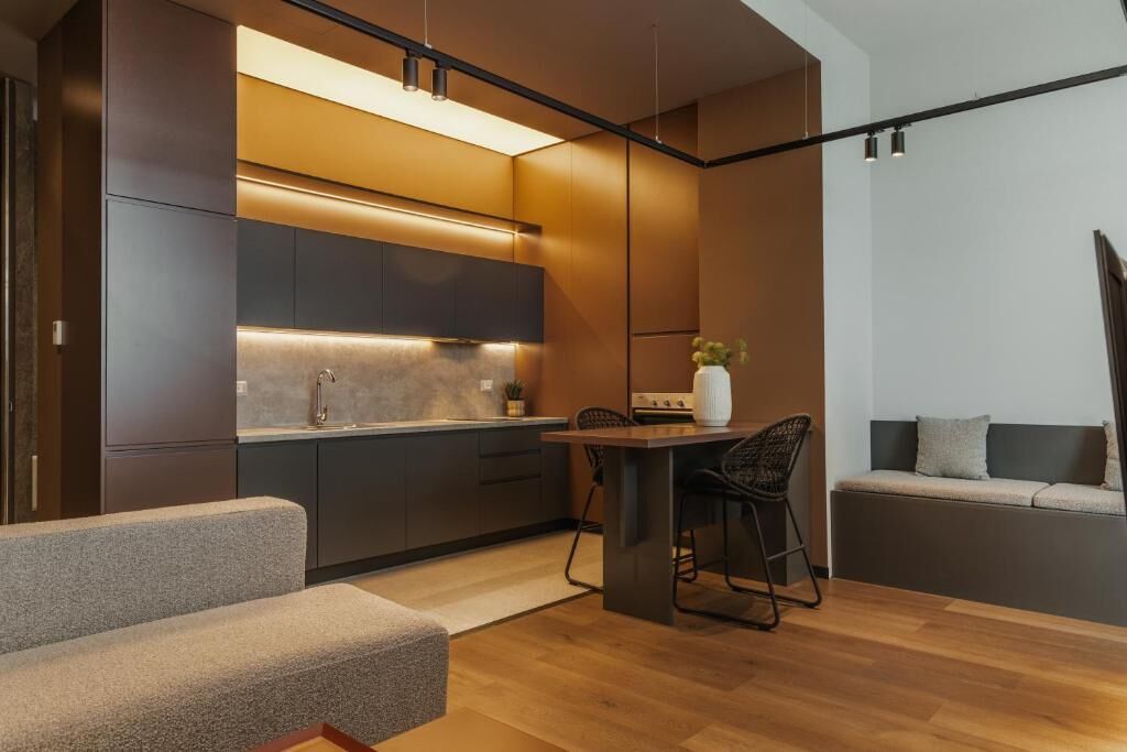 A modern kitchen with dark cabinetry, a central island, and pendant lighting.