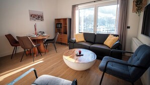 En moderne stue med sofa, sofabord og spiseplads.