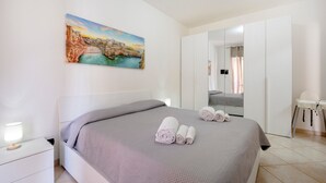 A bedroom with a bed, a nightstand, a painting, a wardrobe, and a chair. - Levante Eight Sea View Holiday Home with Sea View, Wi-Fi, and Air Conditioning (Bari)
