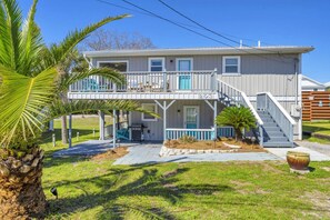A two-story house with a balcony, a porch, and a staircase leading to the upper level. - Sandy Toes Hideaway- Multi Family! (Panama City)