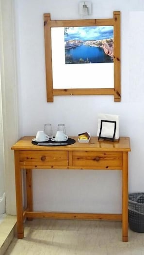 Ein Holztisch mit einem gerahmten Bild, zwei weißen Tassen, einer kleinen Schachtel und einem Bilderrahmen.