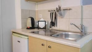 A compact kitchen with a sink, a coffee maker, and a small refrigerator. - malia boutique studios (Malia)