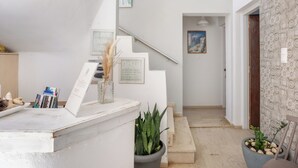 A reception area with a staircase leading to a bedroom. - malia boutique studios (Malia)