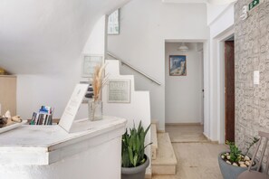 A reception area with a staircase leading to a bedroom. - malia boutique studios (Malia)