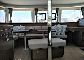 A compact, modern interior with a sofa, a small table, and a bench. - Sun-Kissed Sailing Adventure in the Saronic Islands (Laurium)