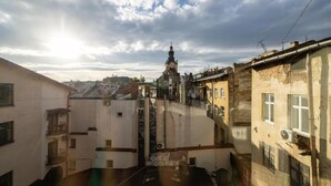 Un patio con un edificio que tiene una torre, rodeado de otras construcciones.