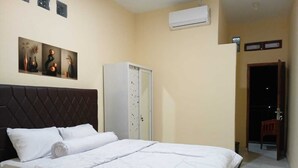 Een hotelkamer met een bed, een kledingkast en een airconditioning.