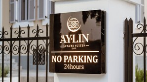 Ein Schild für Aylin Luxury Suites mit der Aufschrift 'KEIN PARKPLATZ, 24 Stunden'.