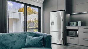 A modern kitchen with a built-in refrigerator, microwave, and toaster. - Coastal Noir - Modern Cottesloe Stay (Cottesloe)
