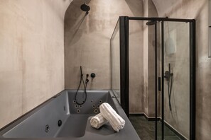 Ein modernes Badezimmer mit Badewanne, Dusche und einer Glaskabine.