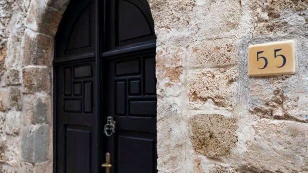 A black door with a brass handle, a stone wall, and a number plate with '55' on it. - Belvedere Medieval Villa in Old Town (Old Town Rhodes)