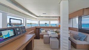 Een modern interieur met een bedieningspaneel, zithoek en grote ramen met uitzicht op de oceaan.