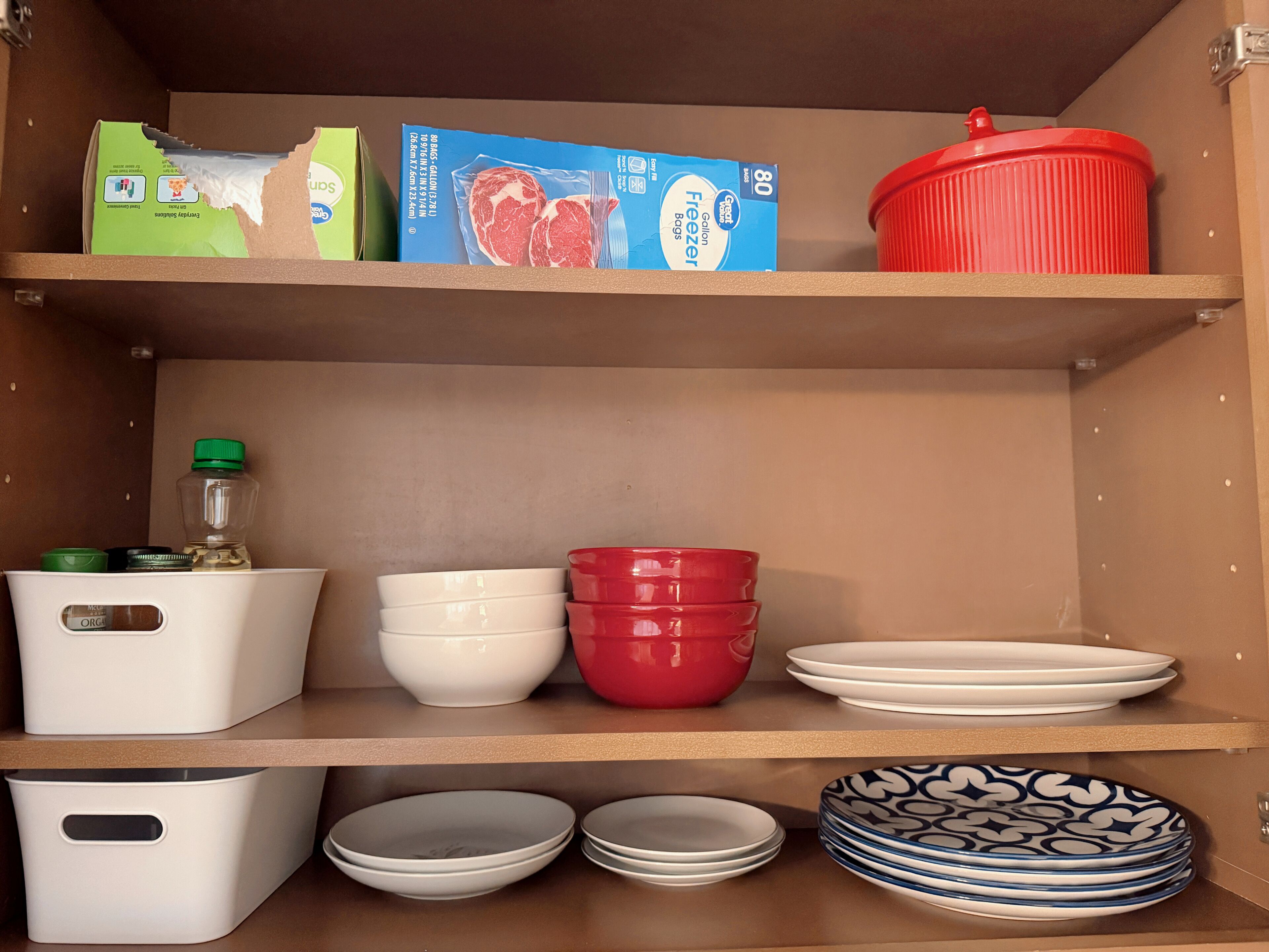 Un garde-manger avec des étagères contenant des produits alimentaires, des récipients de rangement et des ustensiles de cuisine.