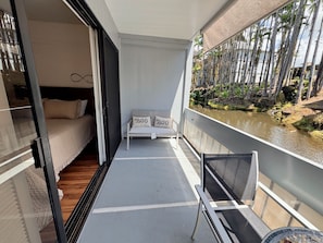 Uma varanda com uma cama, um sofá e uma cadeira.