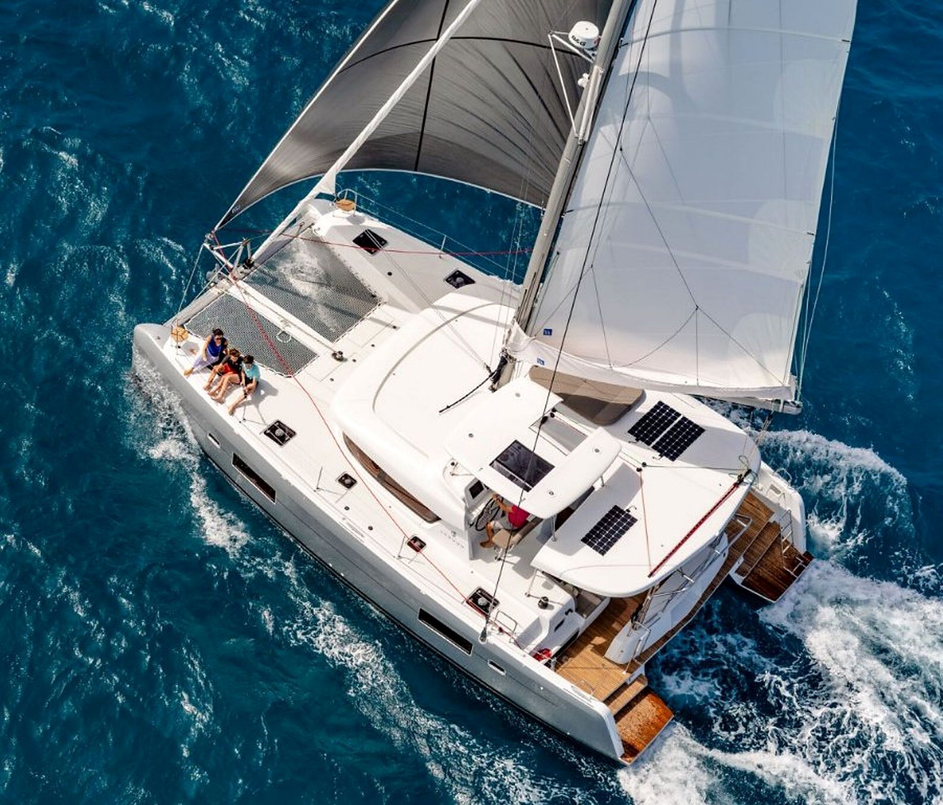 A large yacht with multiple decks, a covered deck area, and a wake behind it.