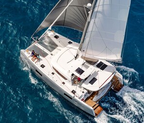 A large yacht with multiple decks, a covered deck area, and a wake behind it. - Sun-Kissed Sailing Adventure in Isla de Mahe, Seychelles (Mahe)