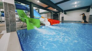 An indoor swimming pool with slides and a penguin statue. - KASTİLYA KIRSAL TURİZİM  TESİSİ (Kastamonu)