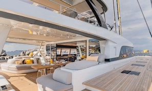 Ein Yacht-Interieur mit Essbereich, Sitzgelegenheiten und Meerblick.