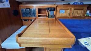 Et træinteriør med et centralt bord, et kontrolpanel og et blåt polstret sæde.