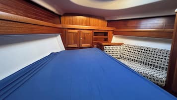A compact interior with a bunk bed, a small seating area, and a skylight.