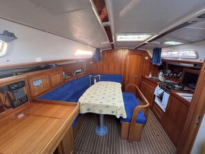 A compact galley with a table, seating, and a stove.
