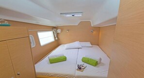 A compact bedroom with a bed, a small window, and a ceiling light. - Sun-Kissed Sailing Adventure in Islas Sarónicas (Alimos)