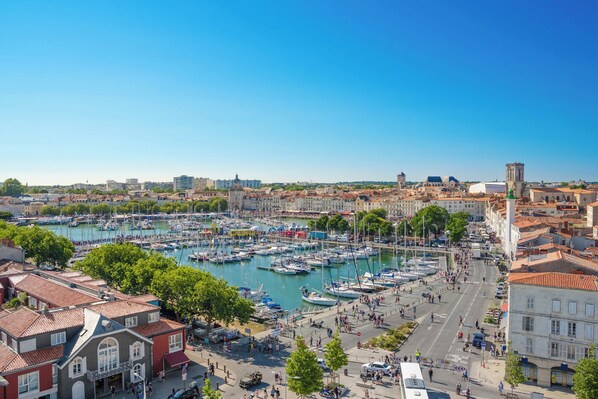 A marina with boats, a cityscape with historic buildings, and a clear sky.