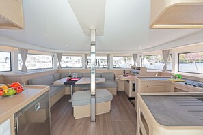 Un interior moderno y funcional con comedor, asientos y kitchenette.