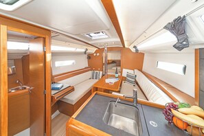 A compact galley with a sink, a small table, and a bench. - Sun-Kissed Sailing Adventure in the Saronic Islands (Laurium)