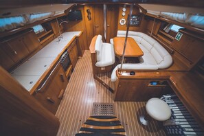 A boat interior with a dining area, a seating area, and a small bathroom. - Sun-Kissed Sailing Adventure in the Sporades Islands from Volos, Thessaly (Elliniko)