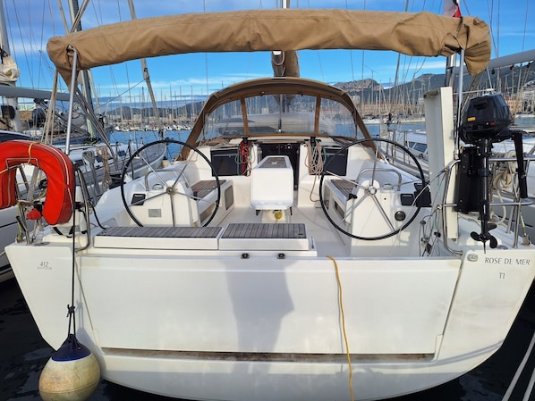 A boat with a cabin, steering wheel, and life preserver. - Sun-Kissed Sailing Adventure in Puerto de Toulon (Toulon)