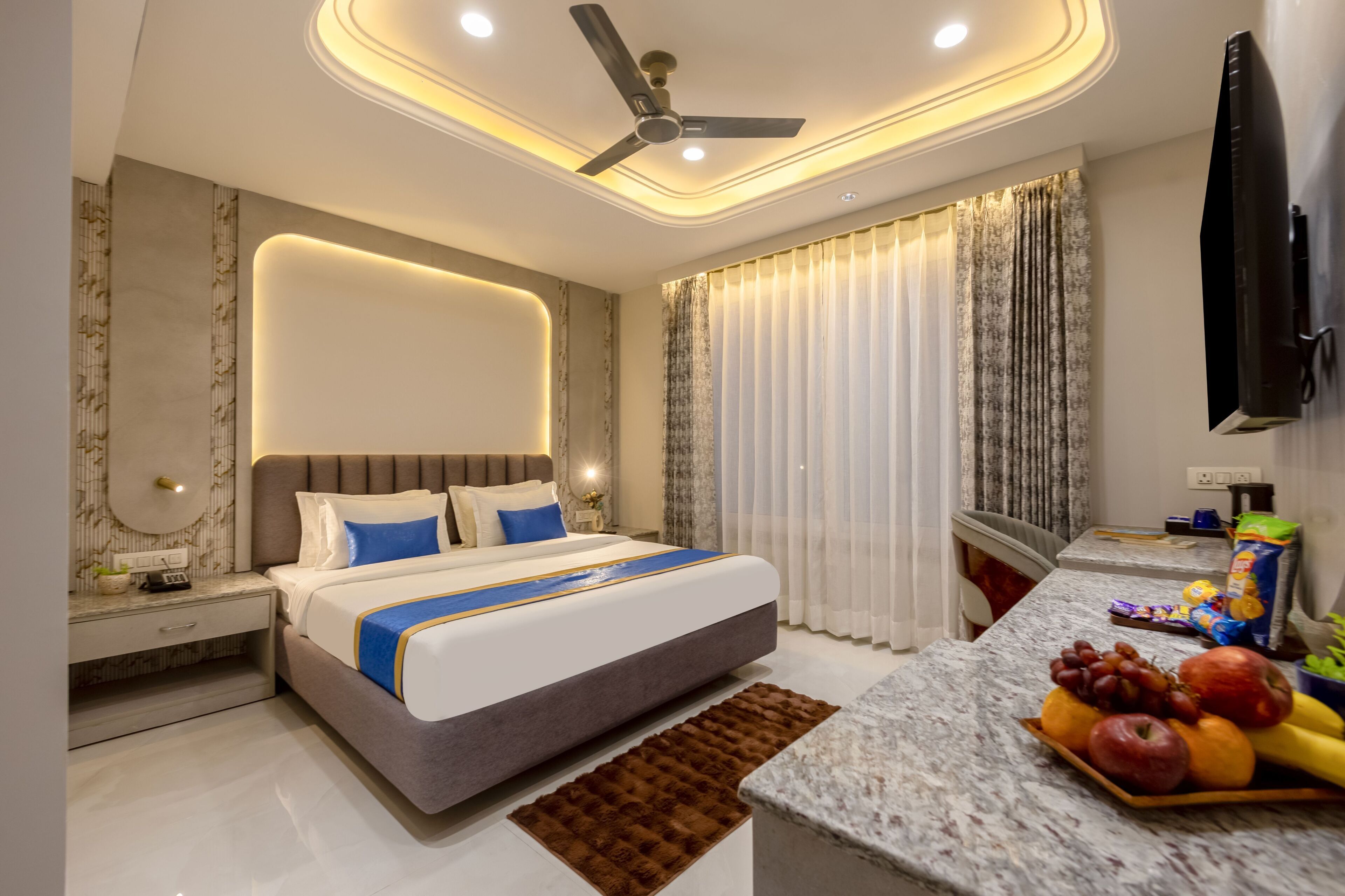 A modern bedroom with a bed, bedside table, nightstand, and a fruit bowl on the side.