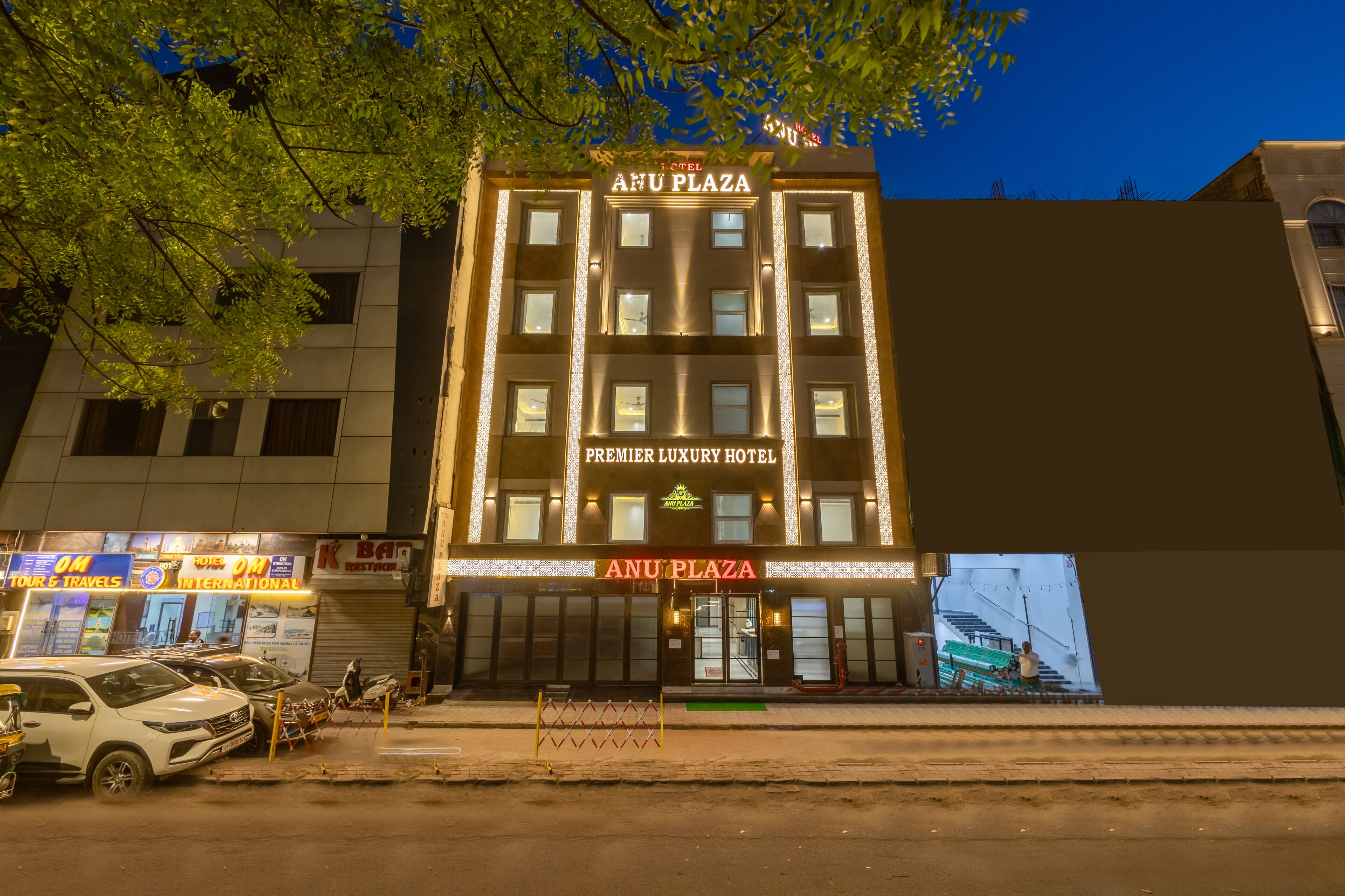 A multi-story hotel with a prominent sign reading 'ANU PLAZA PREMIER LUXURY HOTEL.'